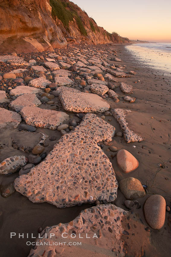 Remains of the old historic "Coast Highway 101", undermined as the bluff upon which it was built eroded away, now broken into pieces of concrete and asphalt blocks and fallen down the sea cliffs, lying on the beach. Carlsbad, California, USA, natural history stock photograph, photo id 22194