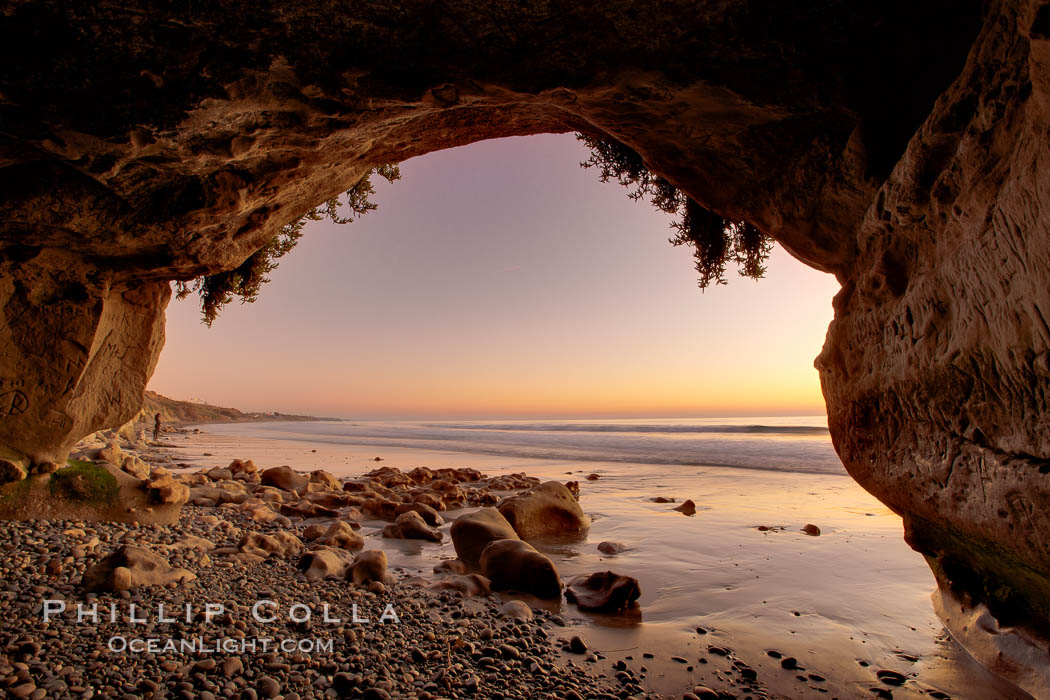 Sarah's Cavern, a natural sea cave hidden below sea cliffs in Carlsbad, opening onto a flat beach at sunset, inner walls adorned with graffiti. California, USA, natural history stock photograph, photo id 22196