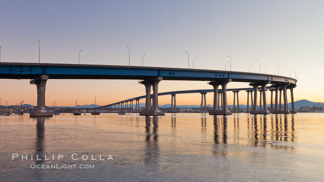 Coronado Bridge, linking San Diego to Coronado, sunrise, viewed from Coronado Island. San Diego Coronado Bridge, known locally as the Coronado Bridge, links San Diego with Coronado, California. The bridge was completed in 1969 and was a toll bridge until 2002. It is 2.1 miles long and reaches a height of 200 feet above San Diego Bay. USA, natural history stock photograph, photo id 27094