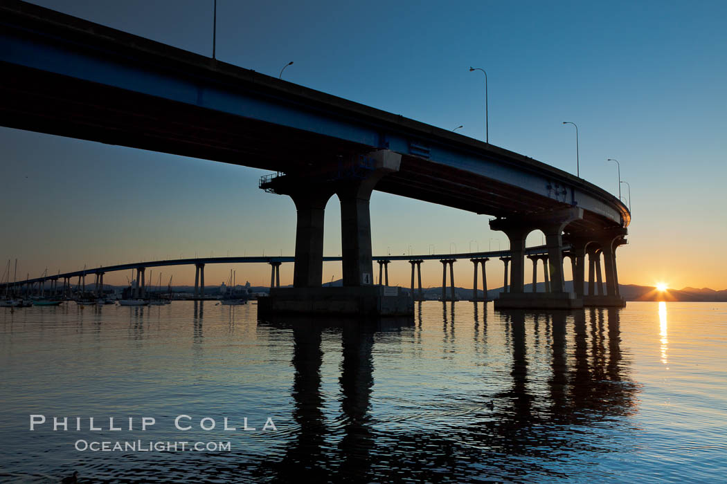 Coronado Bridge, linking San Diego to Coronado, sunrise, viewed from Coronado Island. San Diego Coronado Bridge, known locally as the Coronado Bridge, links San Diego with Coronado, California. The bridge was completed in 1969 and was a toll bridge until 2002. It is 2.1 miles long and reaches a height of 200 feet above San Diego Bay. USA, natural history stock photograph, photo id 27098