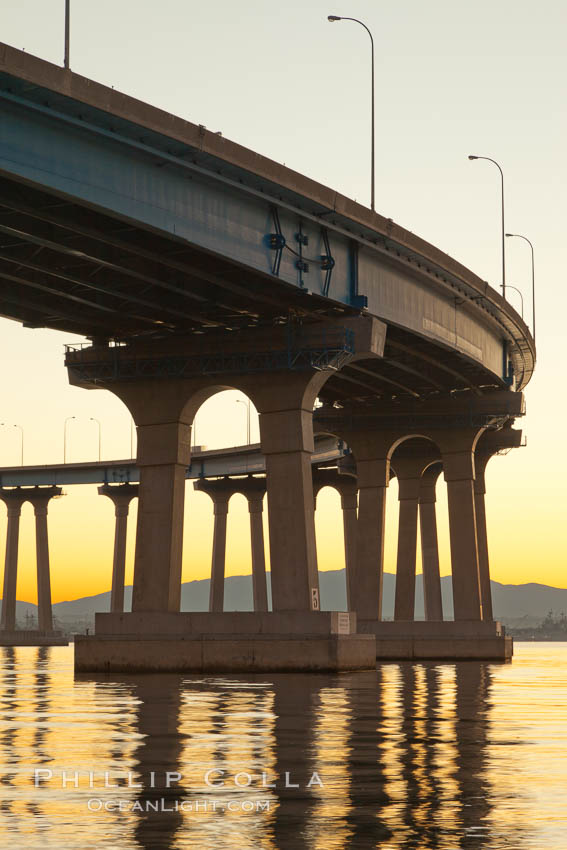 Coronado Bridge, linking San Diego to Coronado, sunrise, viewed from Coronado Island. San Diego Coronado Bridge, known locally as the Coronado Bridge, links San Diego with Coronado, California. The bridge was completed in 1969 and was a toll bridge until 2002. It is 2.1 miles long and reaches a height of 200 feet above San Diego Bay. USA, natural history stock photograph, photo id 27096