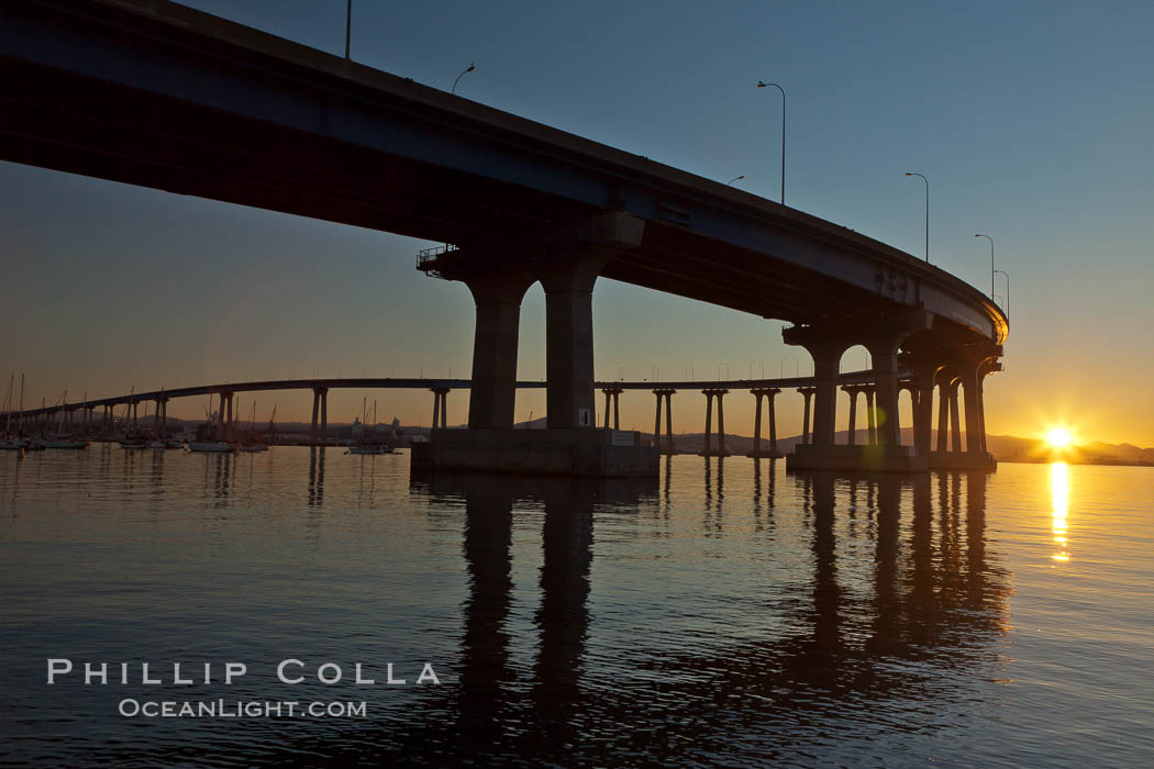 Coronado Bridge, linking San Diego to Coronado, sunrise, viewed from Coronado Island. San Diego Coronado Bridge, known locally as the Coronado Bridge, links San Diego with Coronado, California. The bridge was completed in 1969 and was a toll bridge until 2002. It is 2.1 miles long and reaches a height of 200 feet above San Diego Bay. USA, natural history stock photograph, photo id 27100