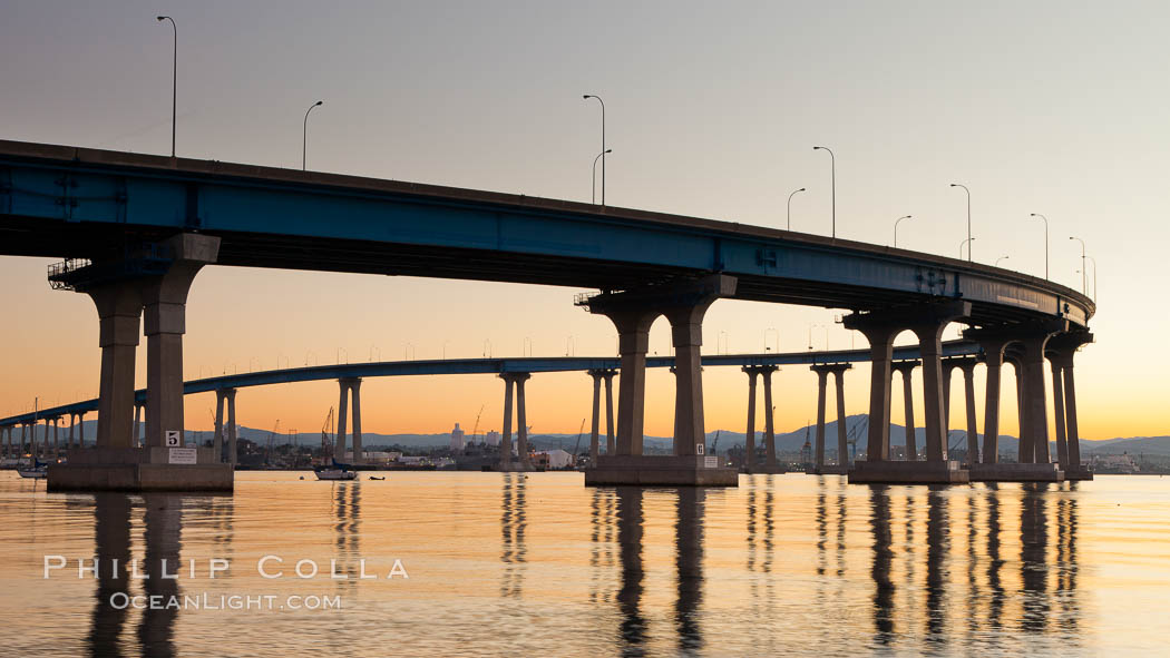 Coronado Bridge, linking San Diego to Coronado, sunrise, viewed from Coronado Island. San Diego Coronado Bridge, known locally as the Coronado Bridge, links San Diego with Coronado, California. The bridge was completed in 1969 and was a toll bridge until 2002. It is 2.1 miles long and reaches a height of 200 feet above San Diego Bay. USA, natural history stock photograph, photo id 27095