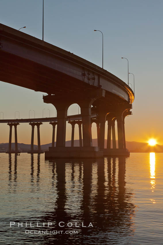 Coronado Bridge, linking San Diego to Coronado, sunrise, viewed from Coronado Island. San Diego Coronado Bridge, known locally as the Coronado Bridge, links San Diego with Coronado, California. The bridge was completed in 1969 and was a toll bridge until 2002. It is 2.1 miles long and reaches a height of 200 feet above San Diego Bay. USA, natural history stock photograph, photo id 27099