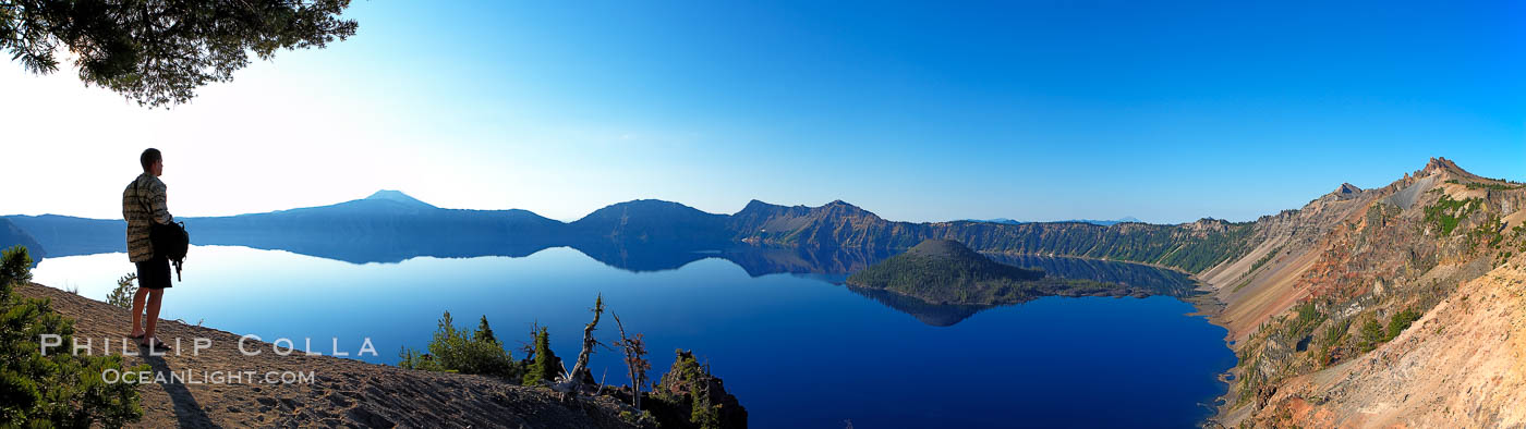 Self portrait at sunrise, panorama of Crater Lake.  Crater Lake is the six-mile wide lake inside the collapsed caldera of volcanic Mount Mazama. Crater Lake is the deepest lake in the United States and the seventh-deepest in the world. Its maximum recorded depth is 1996 feet (608m). It lies at an altitude of 6178 feet (1880m). Crater Lake National Park, Oregon, USA, natural history stock photograph, photo id 19130