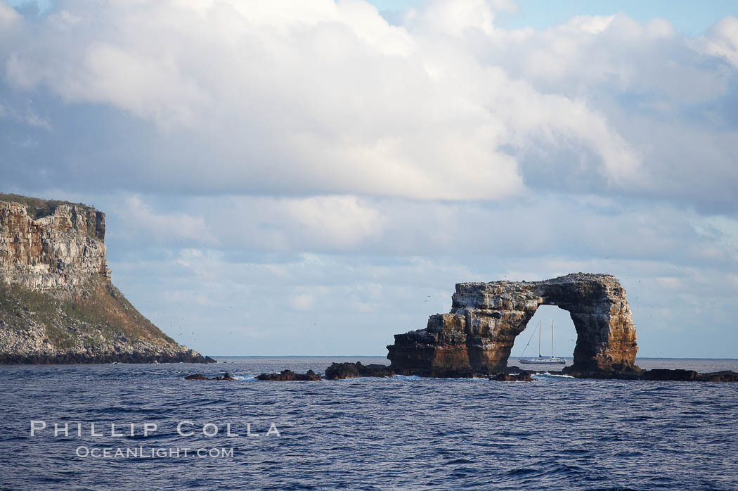 Darwins Arch, a dramatic 50-foot tall natural lava arch, rises above the ocean a short distance offshore of Darwin Island. Galapagos Islands, Ecuador, natural history stock photograph, photo id 16654