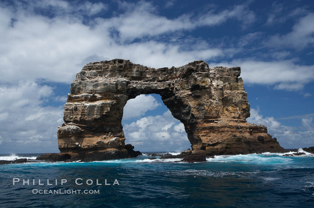 Darwins Arch, a dramatic 50-foot tall natural lava arch, rises above the ocean a short distance offshore of Darwin Island. Galapagos Islands, Ecuador, natural history stock photograph, photo id 16656