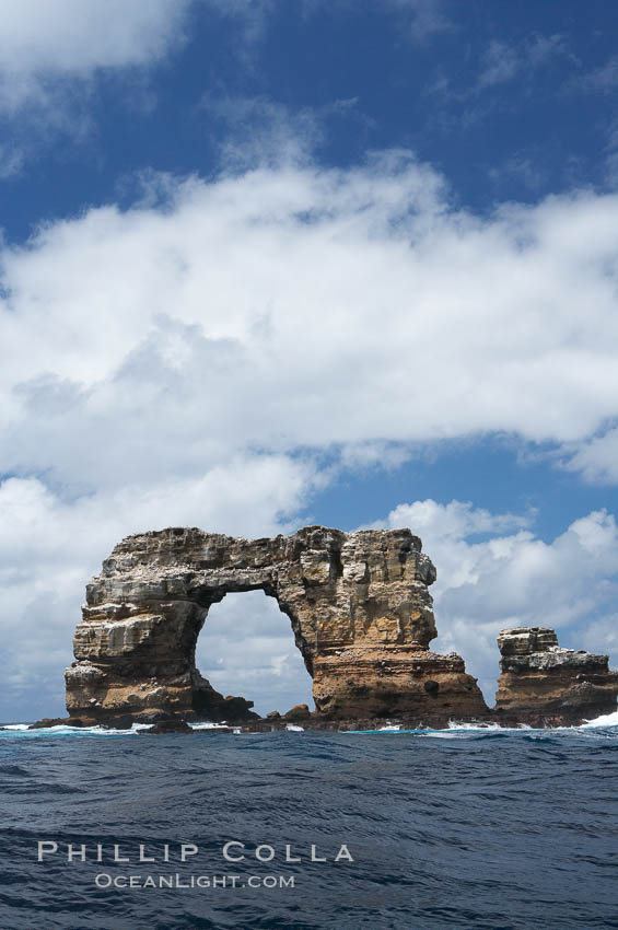 Darwins Arch, a dramatic 50-foot tall natural lava arch, rises above the ocean a short distance offshore of Darwin Island. Galapagos Islands, Ecuador, natural history stock photograph, photo id 16627