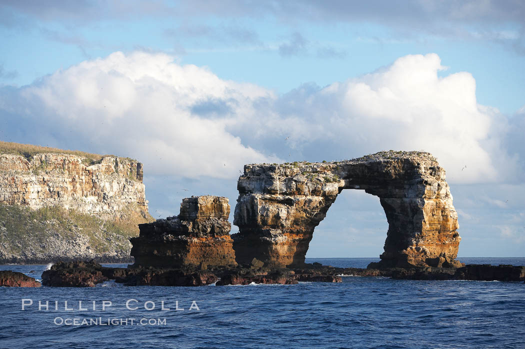 Darwins Arch, a dramatic 50-foot tall natural lava arch, rises above the ocean a short distance offshore of Darwin Island. Galapagos Islands, Ecuador, natural history stock photograph, photo id 16625