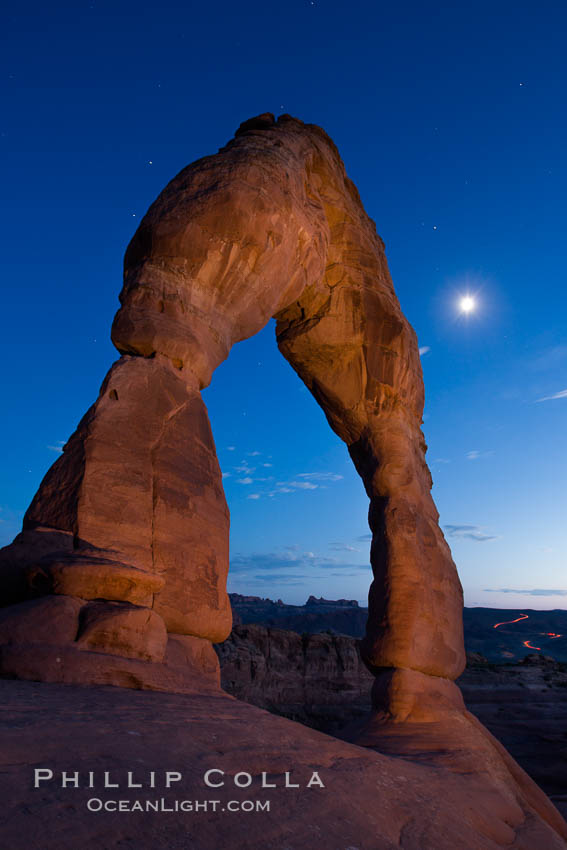 Delicate Arch and the Moon at Sunset.  The moon and clouds, with stars showing faintly in the sky, as sunset fades into night. (Note: this image was created before a ban on light-painting in Arches National Park was put into effect.  Light-painting is no longer permitted in Arches National Park). Utah, USA, natural history stock photograph, photo id 27862