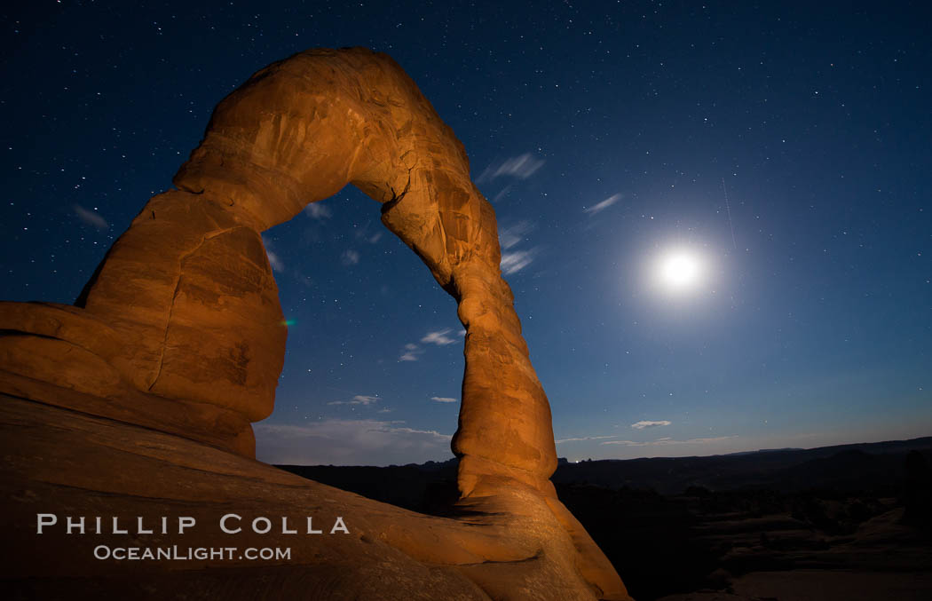 Delicate Arch and the Moon at Sunset.  The moon and clouds, with stars showing faintly in the sky, as sunset fades into night. (Note: this image was created before a ban on light-painting in Arches National Park was put into effect.  Light-painting is no longer permitted in Arches National Park). Utah, USA, natural history stock photograph, photo id 27863