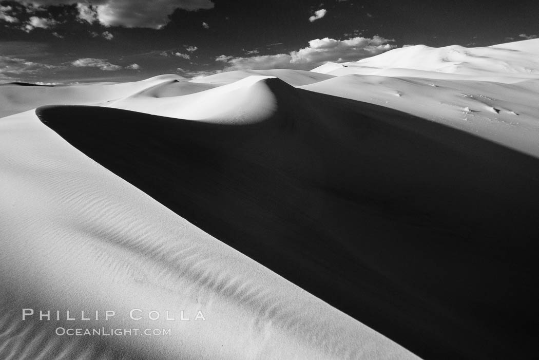 Eureka Sand Dunes, infrared black and white.  The Eureka Dunes are California's tallest sand dunes, and one of the tallest in the United States.  Rising 680' above the floor of the Eureka Valley, the Eureka sand dunes are home to several endangered species, as well as "singing sand" that makes strange sounds when it shifts. Death Valley National Park, USA, natural history stock photograph, photo id 25377