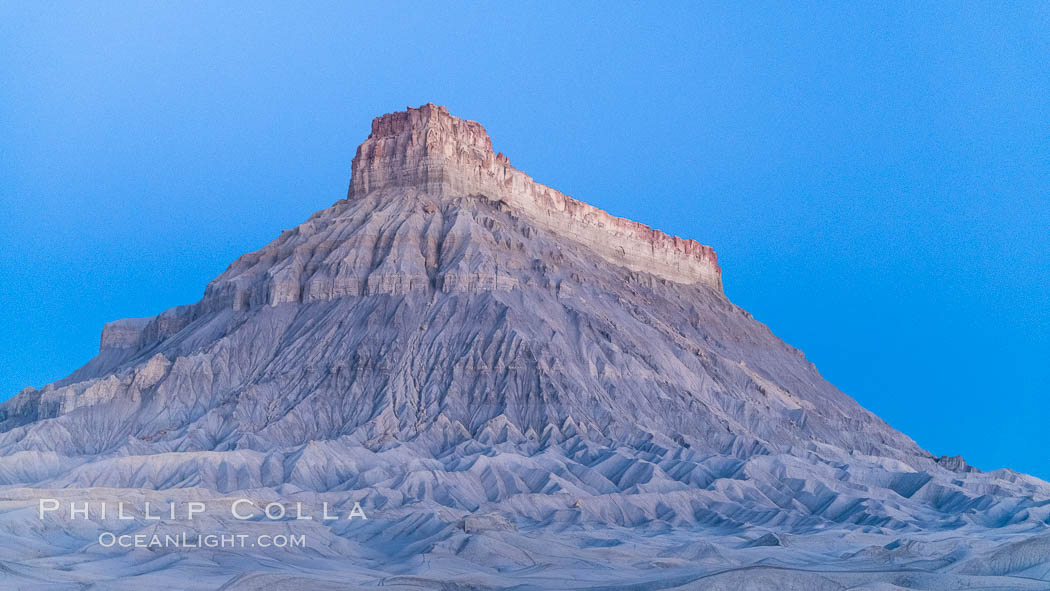 Factory Butte at sunrise. An exceptional example of solitary butte surrounded by dramatically eroded badlands, Factory Butte stands alone on the San Rafael Swell. Hanksville, Utah, USA, natural history stock photograph, photo id 37018
