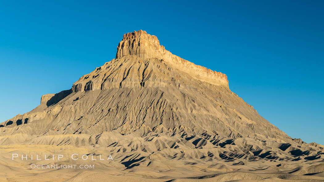 Factory Butte at sunrise. An exceptional example of solitary butte surrounded by dramatically eroded badlands, Factory Butte stands alone on the San Rafael Swell. Hanksville, Utah, USA, natural history stock photograph, photo id 37020