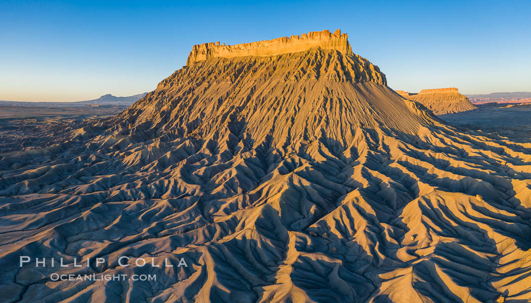 Factory Butte at sunrise, aerial photo, Utah. An exceptional example of solitary butte surrounded by dramatically eroded badlands, Factory Butte stands alone on the San Rafael Swell. Hanksville, USA, natural history stock photograph, photo id 38076