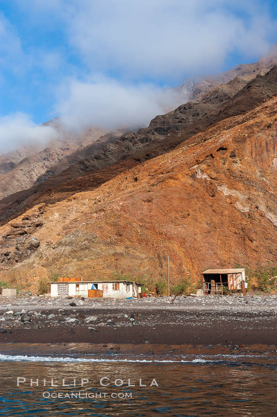 Guadalupe Islands steep cliffs tower above a small fishing shack, lighthouse, old chapel and prison near the north end of Guadalupe Island (Isla Guadalupe). Baja California, Mexico, natural history stock photograph, photo id 09733