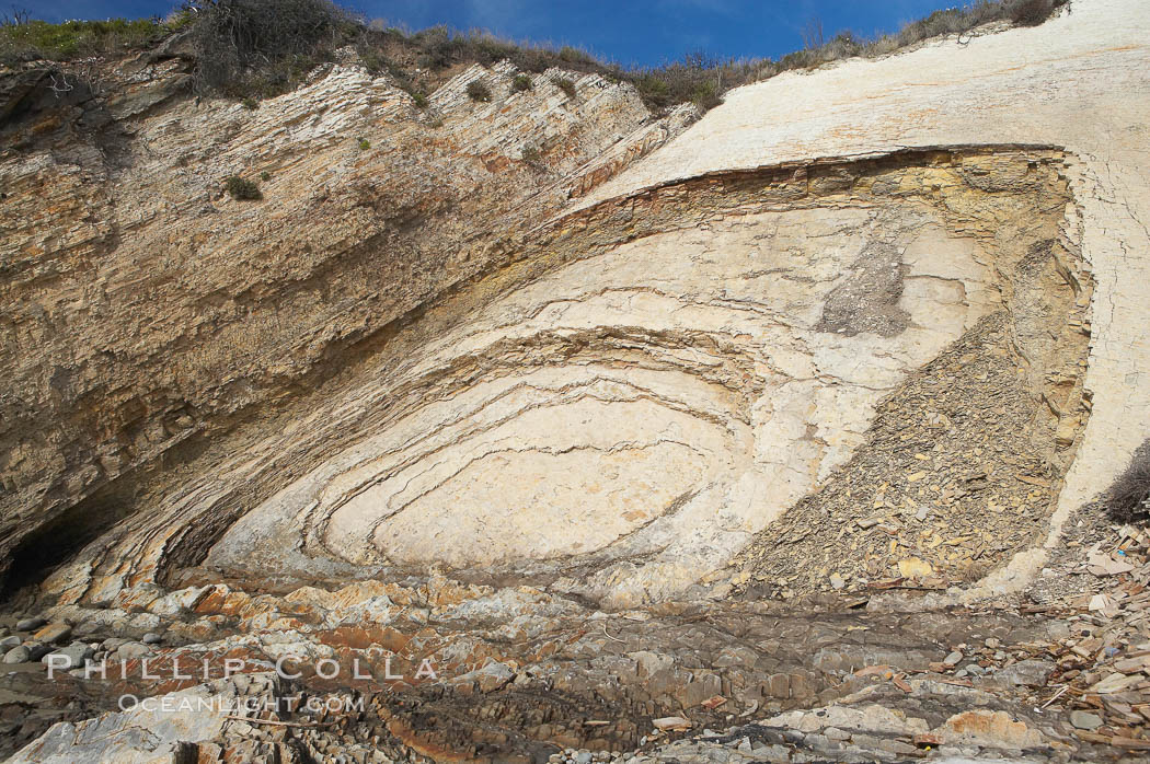 Shale is a fine-grained detrital sedimentary rock formed by the compaction of clay, silt, or mud.  Shale is formed when mud is pressed into rock over millions of years and often breaks into big flat pieces. Here layers of shale emerge from the sand and cliffs at Gaviota State Beach north of Santa Barbara. California, USA, natural history stock photograph, photo id 14892