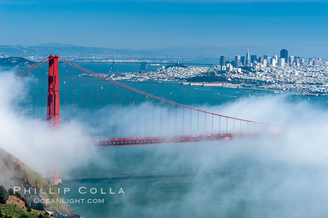 San Franciscos infamous summer fog overtakes the Golden Gate Bridge, viewed from the Marin Headlands with the city of San Francisco visible in the distance. California, USA, natural history stock photograph, photo id 09060