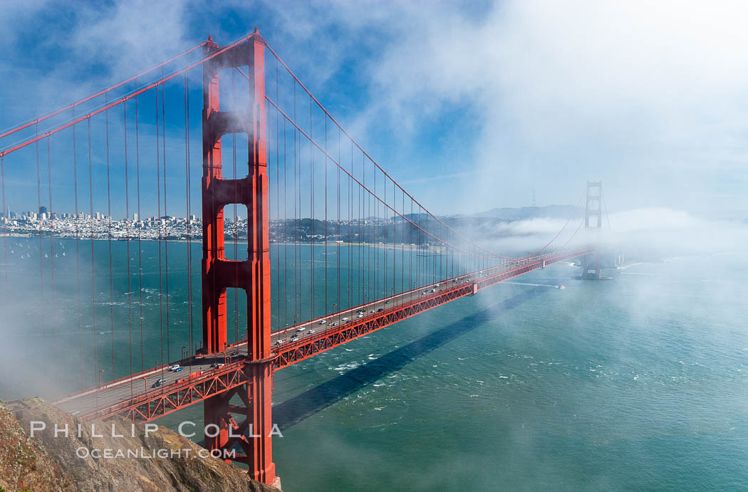 San Franciscos infamous summer fog overtakes the Golden Gate Bridge, viewed from the Marin Headlands with the city of San Francisco visible in the distance. California, USA, natural history stock photograph, photo id 09064