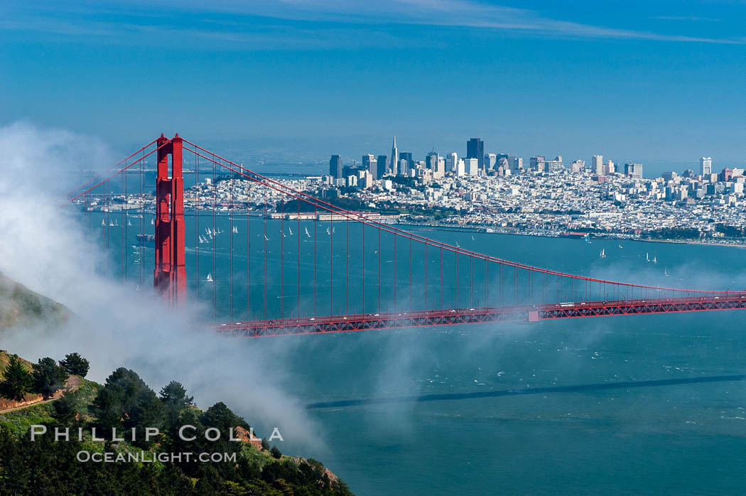 San Franciscos infamous summer fog overtakes the Golden Gate Bridge, viewed from the Marin Headlands with the city of San Francisco visible in the distance. California, USA, natural history stock photograph, photo id 09061