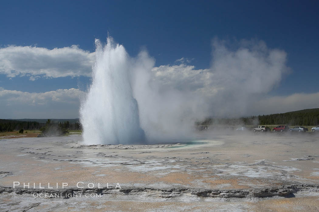 Great Fountain Geyser erupting.  Great Fountain Geyser, a fountain-type geyser, can reach heights of 200 feet, one of the largest geysers in the world.  It has a large vent (16 feet across) situated amid wide sinter terraces that act as reflecting pools as the geyser slows fills prior to its eruption.  Its interval and duration vary widely.  It typically erupts in a series of bursts, each separately by a few minutes.  Firehole Lake Drive. Lower Geyser Basin, Yellowstone National Park, Wyoming, USA, natural history stock photograph, photo id 13563
