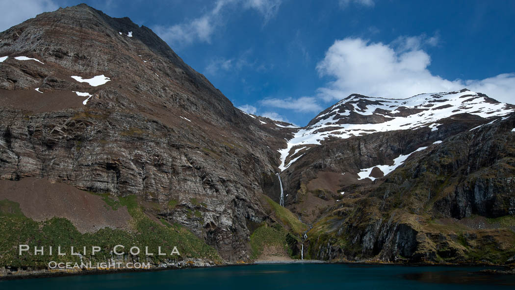 Hercules Bay, with the steep mountains and narrow waterfalls of South Georgia Island rising above., natural history stock photograph, photo id 24467