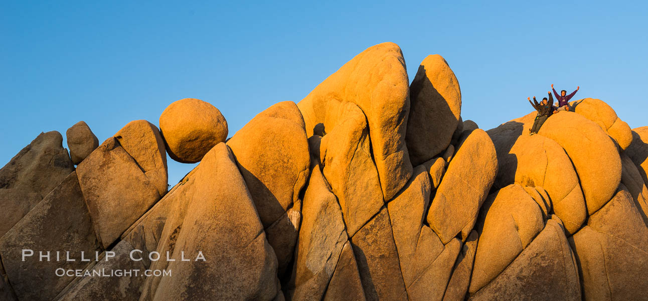 Hikers atop Jumbo Rocks at sunset, warm last light falling on the boulders. Joshua Tree National Park, California, USA, natural history stock photograph, photo id 29185