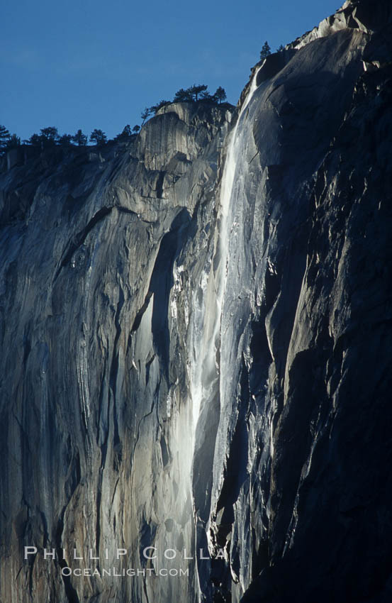 Horsetail Falls backlit by the setting sun as it cascades down the face of El Capitan, February, Yosemite Valley. Yosemite National Park, California, USA, natural history stock photograph, photo id 07050