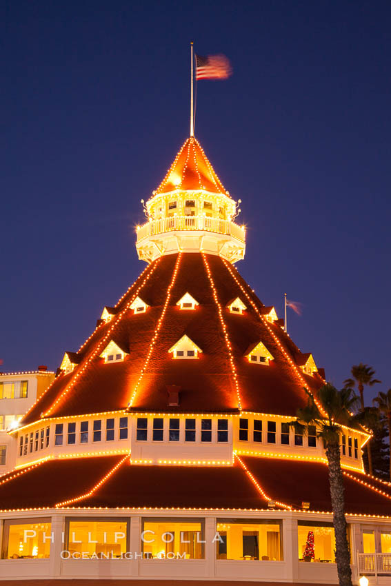 Hotel del Coronado with holiday Christmas night lights, known affectionately as the Hotel Del. It was once the largest hotel in the world, and is one of the few remaining wooden Victorian beach resorts. It sits on the beach on Coronado Island, seen here with downtown San Diego in the distance. It is widely considered to be one of Americas most beautiful and classic hotels. Built in 1888, it was designated a National Historic Landmark in 1977. California, USA, natural history stock photograph, photo id 27400