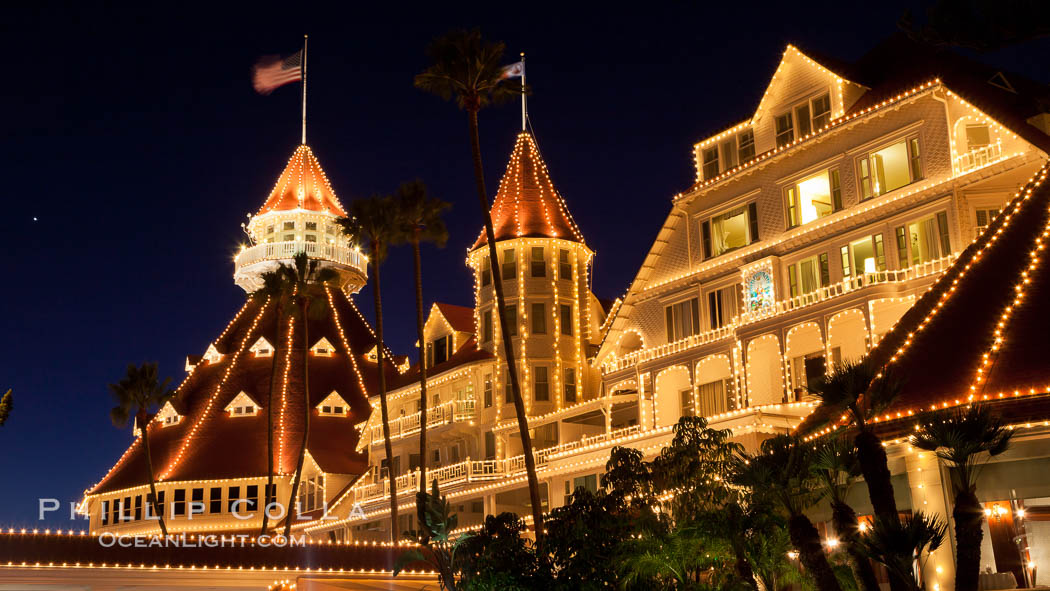 Hotel del Coronado with holiday Christmas night lights, known affectionately as the Hotel Del. It was once the largest hotel in the world, and is one of the few remaining wooden Victorian beach resorts. It sits on the beach on Coronado Island, seen here with downtown San Diego in the distance. It is widely considered to be one of Americas most beautiful and classic hotels. Built in 1888, it was designated a National Historic Landmark in 1977. California, USA, natural history stock photograph, photo id 27404