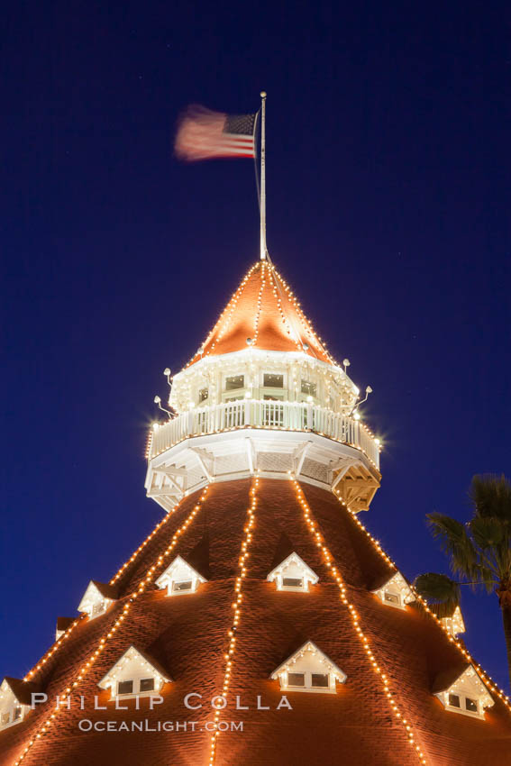 Hotel del Coronado with holiday Christmas night lights, known affectionately as the Hotel Del. It was once the largest hotel in the world, and is one of the few remaining wooden Victorian beach resorts. It sits on the beach on Coronado Island, seen here with downtown San Diego in the distance. It is widely considered to be one of Americas most beautiful and classic hotels. Built in 1888, it was designated a National Historic Landmark in 1977. California, USA, natural history stock photograph, photo id 27403