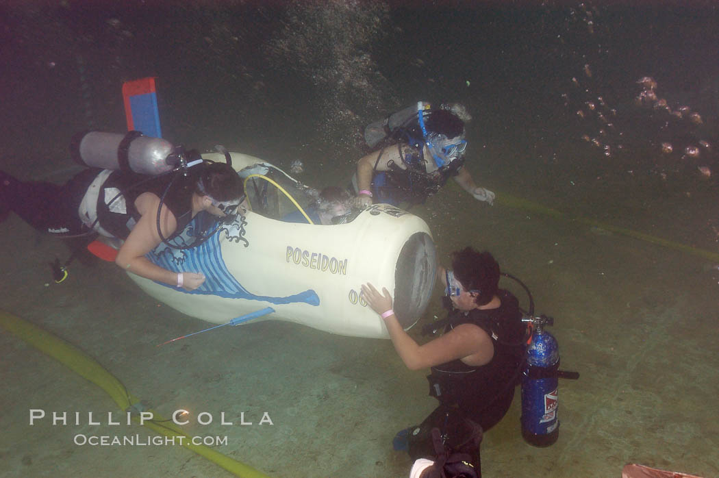 Student engineers prepare a human-powered submarine for an underwater time trial.  The submarines pilot and source of power is visible in the cockpit, and breathes on SCUBA while operating the sub.  The submersible was designed, built and operated by High Tech High School (San Diego, California) engineering students. Offshore Model Basin, Escondido, USA, natural history stock photograph, photo id 09779