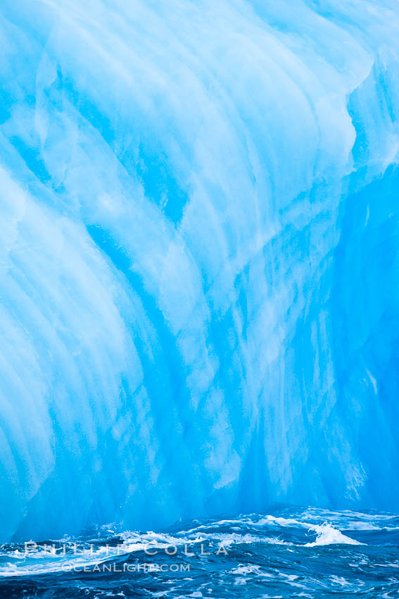 A blue iceberg.  Blue icebergs are blue because the ice from which they are formed has been compressed under such enormous pressure that all gas (bubbles) have been squeezed out, leaving only solid water that takes on a deep blue color. Scotia Sea, Southern Ocean, natural history stock photograph, photo id 24846