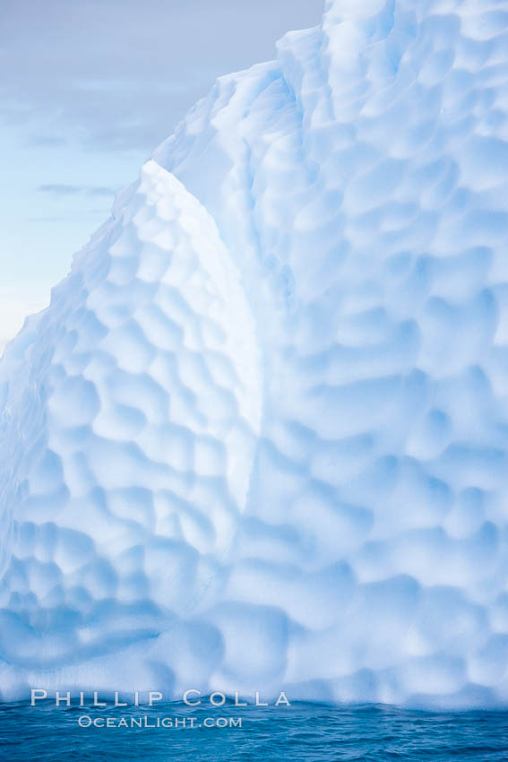 Iceberg with scalloped erosion.  The eroded indentations on this iceberg were melted when this portion of the iceberg was underwater.  As it melted, the iceberg grew topheavy, eventually flipping and exposing this interesting surface. Paulet Island, Antarctic Peninsula, Antarctica, natural history stock photograph, photo id 24829