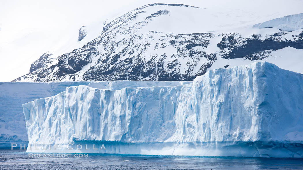 Iceberg and snow-covered coastline, Antarctic Sound. Antarctic Peninsula, Antarctica, natural history stock photograph, photo id 24877