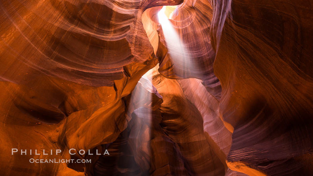 Light Beam in Upper Antelope Slot Canyon.  Thin shafts of light briefly penetrate the convoluted narrows of Upper Antelope Slot Canyon, sending piercing beams through the sandstone maze to the sand floor below. Navajo Tribal Lands, Page, Arizona, USA, natural history stock photograph, photo id 28564