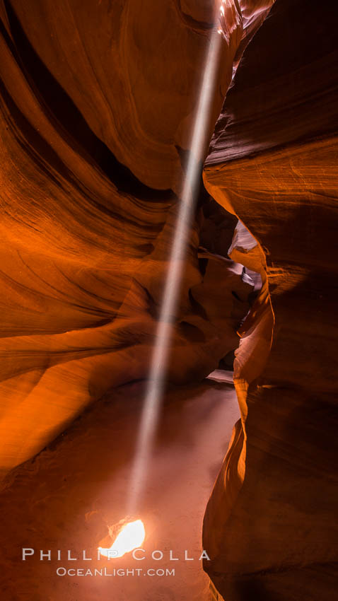 Light Beam in Upper Antelope Slot Canyon.  Thin shafts of light briefly penetrate the convoluted narrows of Upper Antelope Slot Canyon, sending piercing beams through the sandstone maze to the sand floor below. Navajo Tribal Lands, Page, Arizona, USA, natural history stock photograph, photo id 28568
