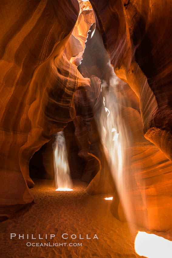 Light Beam in Upper Antelope Slot Canyon.  Thin shafts of light briefly penetrate the convoluted narrows of Upper Antelope Slot Canyon, sending piercing beams through the sandstone maze to the sand floor below. Navajo Tribal Lands, Page, Arizona, USA, natural history stock photograph, photo id 28561