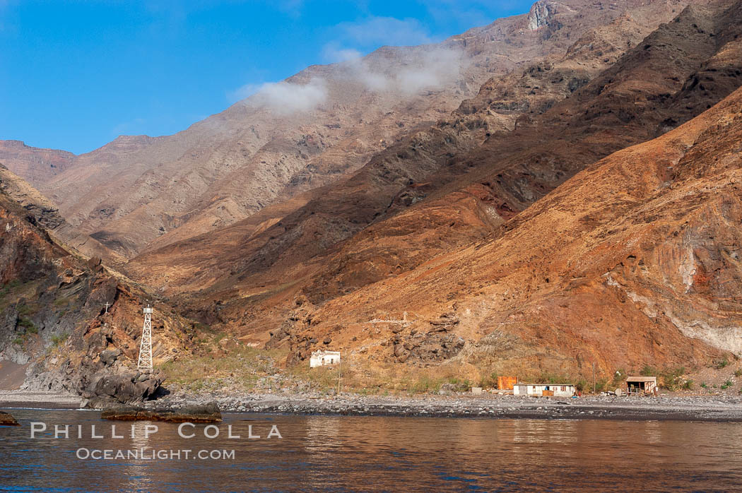 Guadalupe Islands steep cliffs tower above a small fishing shack, lighthouse, old chapel and prison near the north end of Guadalupe Island (Isla Guadalupe). Baja California, Mexico, natural history stock photograph, photo id 09735