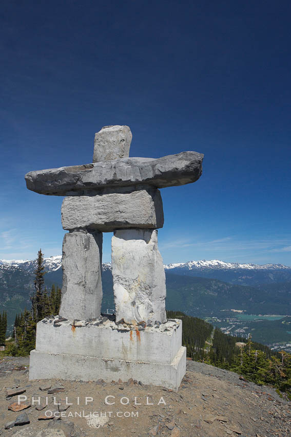Ilanaaq, the logo of the 2010 Winter Olympics in Vancouver, is formed of stone in the Inukshuk-style of traditional Inuit sculpture.  Located near the Whistler mountain gondola station, overlooking Whistler Village and Green Lake in the distance. British Columbia, Canada, natural history stock photograph, photo id 21010