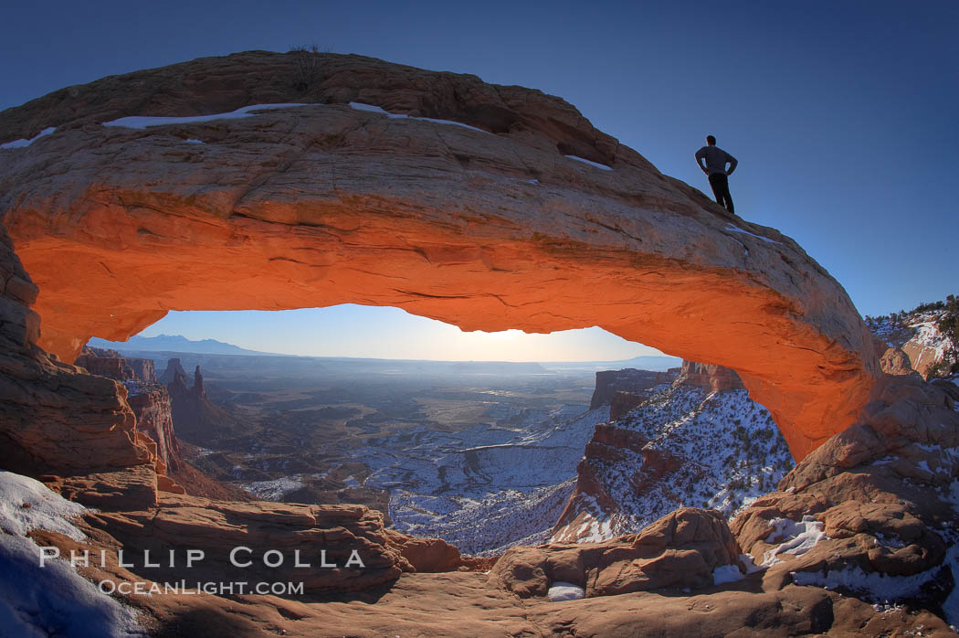 Mesa Arch, spectacular stone arch overlooking Canyonlands National Park.  An hiker watches the dawning sun from atop Mesa Arch. Island in the Sky, Utah, USA, natural history stock photograph, photo id 18038
