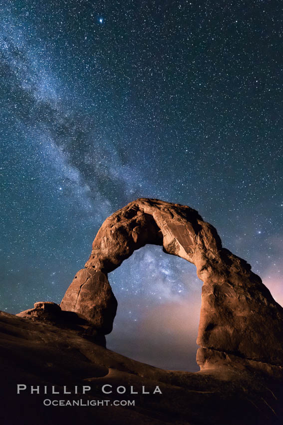 Milky Way and Stars over Delicate Arch, at night, Arches National Park, Utah (Note: this image was created before a ban on light-painting in Arches National Park was put into effect.  Light-painting is no longer permitted in Arches National Park). USA, natural history stock photograph, photo id 29298