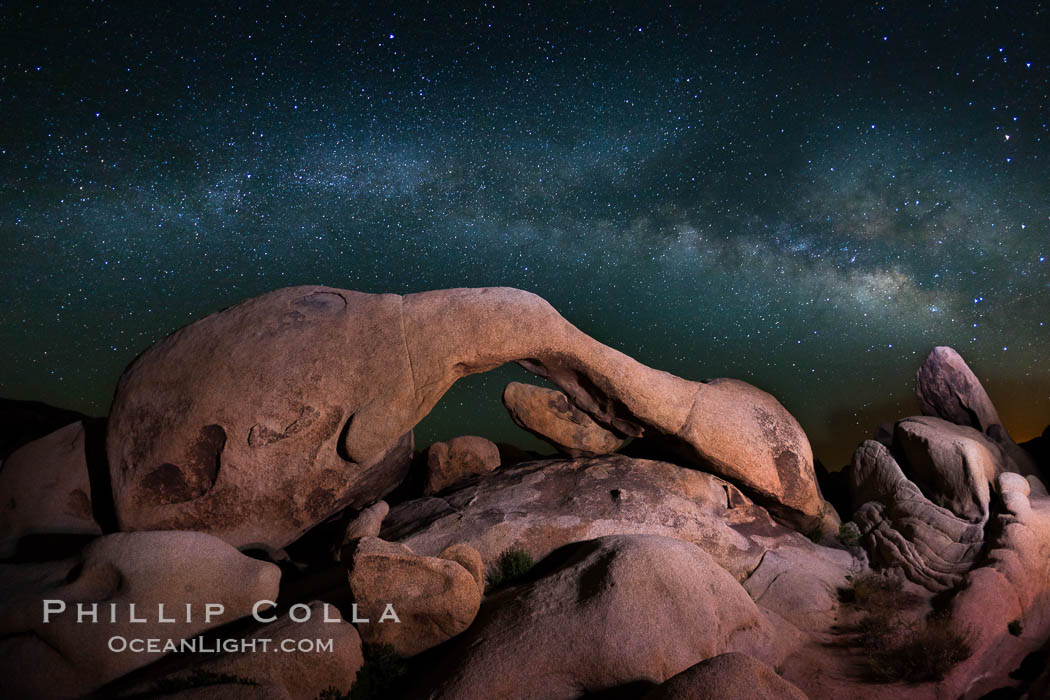 Image 26801, The Milky Way galaxy arches over Arch Rock on a clear evening in Joshua Tree National Park. California, USA, Phillip Colla, all rights reserved worldwide. Keywords: arch, astrophotography, california, dark, evening, galaxy, granite, heavens, joshua tree national park, landscape, landscape astrophotography, milky way, milky way galaxy, national park, natural arch, night, outdoors, outside, rock, rock arch, scene, scenery, scenic, sky, star field, stars, stone, stone arch.