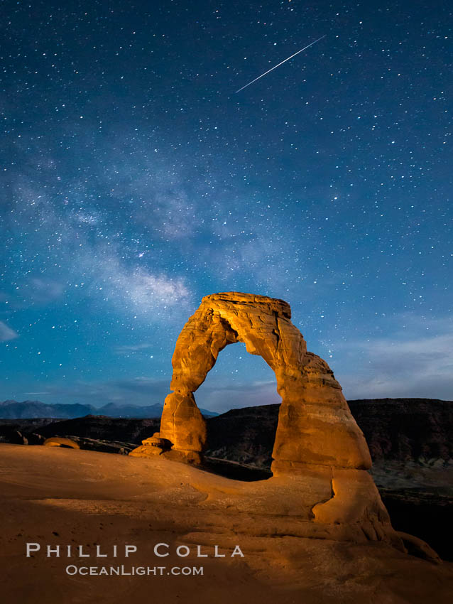 Milky Way and Shooting Star over Delicate Arch, as stars cover the night sky. (Note: this image was created before a ban on light-painting in Arches National Park was put into effect.  Light-painting is no longer permitted in Arches National Park). Utah, USA, natural history stock photograph, photo id 27854