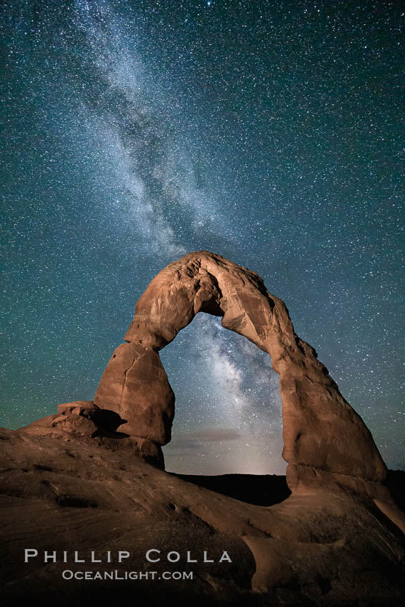 Milky Way arches over Delicate Arch, as stars cover the night sky. (Note: this image was created before a ban on light-painting in Arches National Park was put into effect.  Light-painting is no longer permitted in Arches National Park). Utah, USA, natural history stock photograph, photo id 27849
