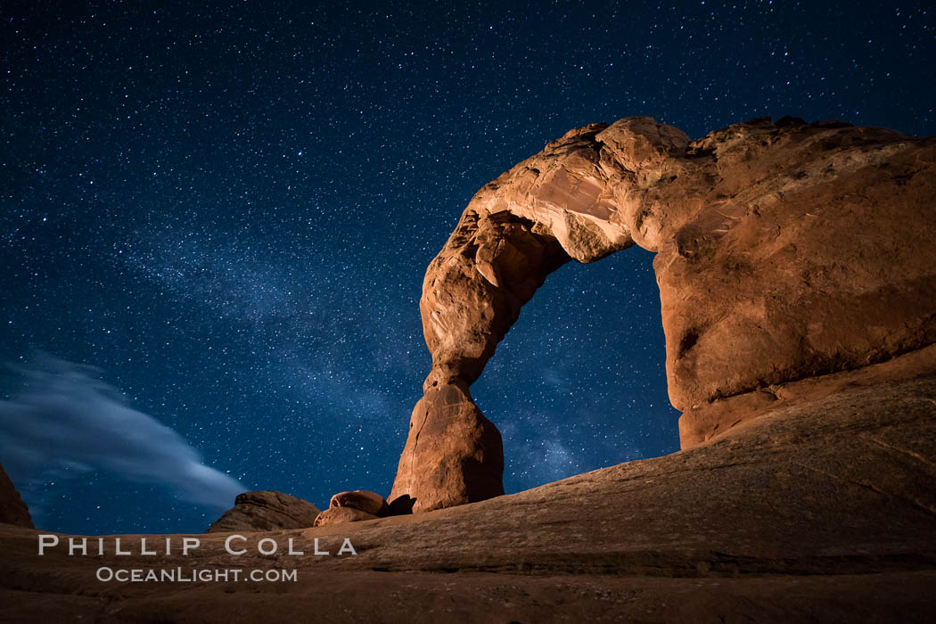 Milky Way arches over Delicate Arch, as stars cover the night sky. (Note: this image was created before a ban on light-painting in Arches National Park was put into effect.  Light-painting is no longer permitted in Arches National Park). Utah, USA, natural history stock photograph, photo id 27857
