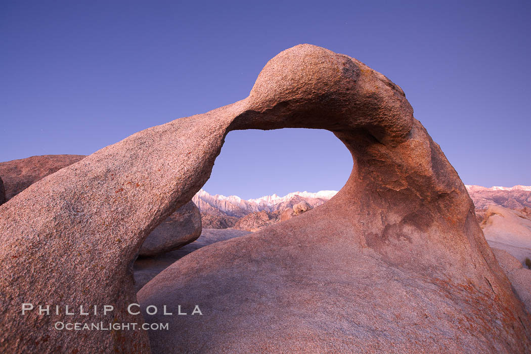 Mobius Arch, with snow covered Mt. Whitney and the Sierra Nevada Range framed within the natural stone arch.  Mt. Whitney is the highest peak in the continental United States. Alabama Hills Recreational Area, California, USA, natural history stock photograph, photo id 21742