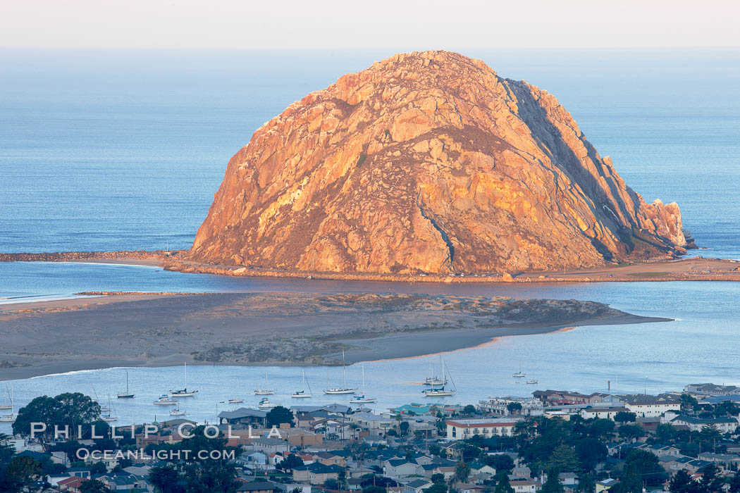 Morro Rock lit at sunrise, rises above Morro Bay which is still in early morning shadow. California, USA, natural history stock photograph, photo id 22219