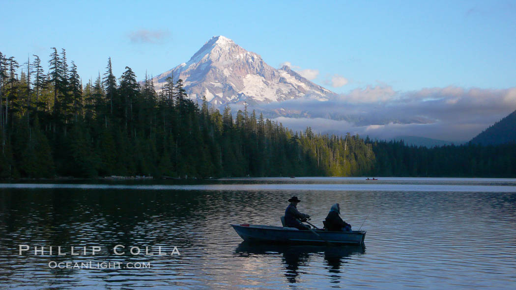 Mount Hood rises above Lost Lake, two old people fishing from a small boat, sunset. Mt. Hood National Forest, Oregon, USA, natural history stock photograph, photo id 19804