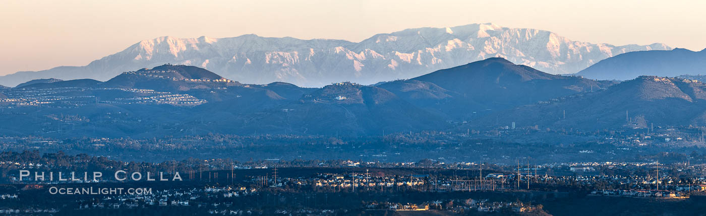 Snow-covered Mount San Gorgonio, seen beyond Double Peak Park in San Marcos, viewed from Mount Soledad in La Jolla, on an exceptionally clear winter day. Double Peak is about 20 miles away while the San Bernardino Mountains are about 90 miles distant. In the foreground are UCSD (University of California at San Diego, left), Veterans Administration Hospital (center) and Scripps La Jolla Medical Center (right)., natural history stock photograph, photo id 37588